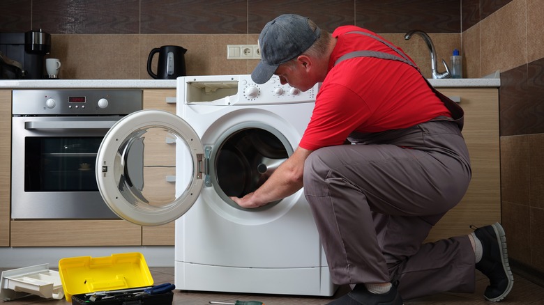 A,Service,Technician,In,Uniform,Repairs,A,Household,Washing,Machine. washing machine repair in riyadh